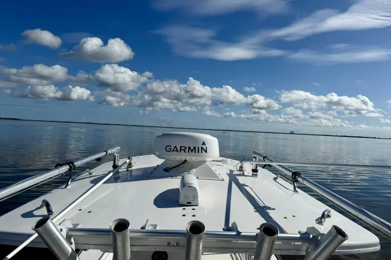 Slide: The Image of 2006 Regulator 29 Forward Seating boat with Garmin equipment on calm water under blue sky. - 12