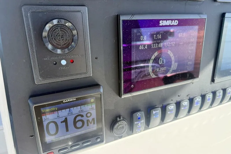 Slide: The Image of Control panel of a 2006 Regulator 29 Forward Seating boat with Simrad and Garmin displays. - 16
