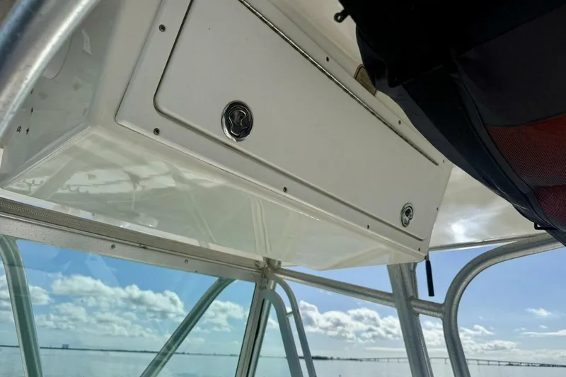 Slide: The Image of 2006 Regulator 29 Forward Seating boat interior with storage compartment and clear sky view. - 26