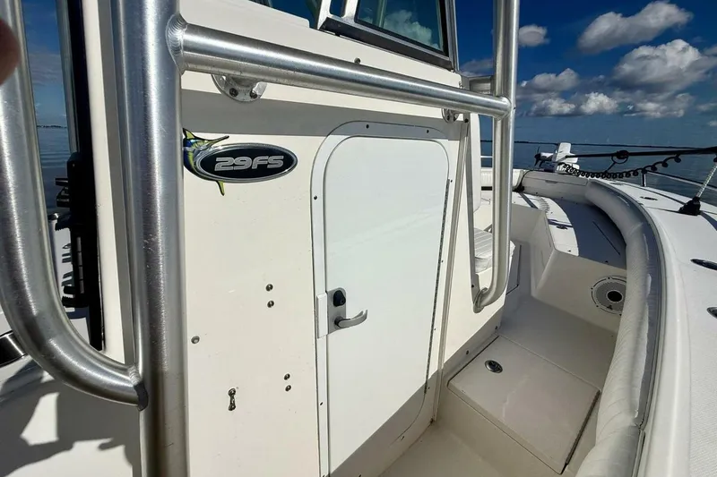 Slide: The Image of 2006 Regulator 29 Forward Seating boat, white exterior, stainless steel railings, clear sky background. - 27