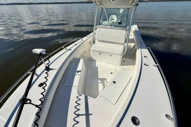 Slide: The Image of 2006 Regulator 29 Forward Seating boat on calm water, showcasing spacious deck and seating. - 30