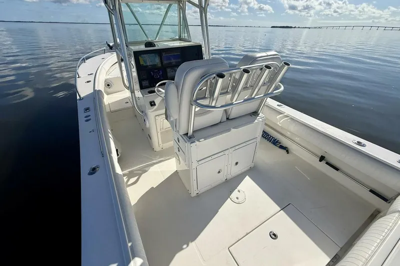 Slide: The Image of 2006 Regulator 29 Forward Seating boat interior with helm and seating, on calm water. - 4