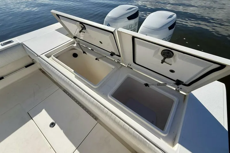 Slide: The Image of 2006 Regulator 29 Forward Seating boat with open storage compartments and dual Suzuki engines. - 42