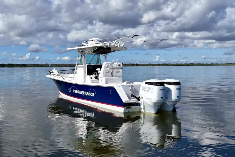 Slide: The Image of 2006 Regulator 29 Forward Seating boat with twin Suzuki engines on calm water. - 46