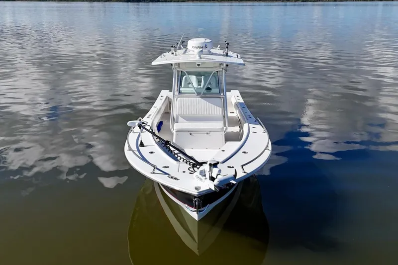 Slide: The Image of 2006 Regulator 29 Forward Seating boat on calm water, featuring Garmin equipment. - 7