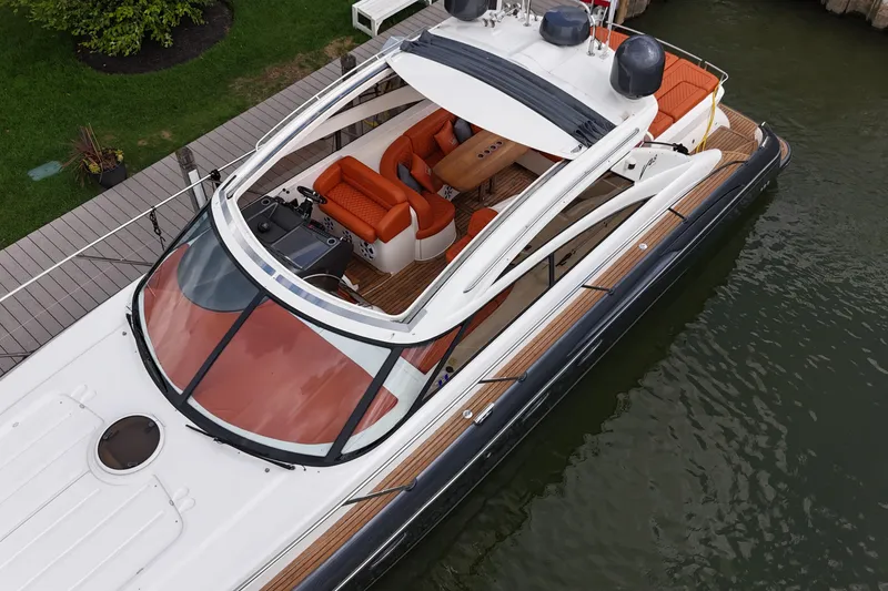 Slide: The Image of 2006 Princess V48 yacht with sleek design, orange seating, docked by the water. - 1