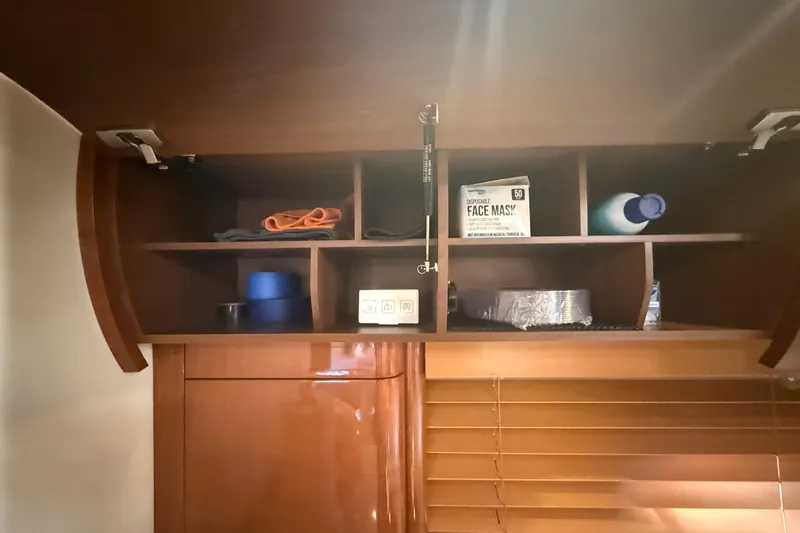 Slide: The Image of Open wooden cabinet in 2006 Princess V48 yacht with face masks and cleaning supplies. - 16