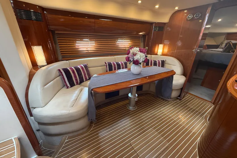 Slide: The Image of Luxurious 2006 Princess V48 yacht interior with elegant seating, wooden table, and floral centerpiece. - 27