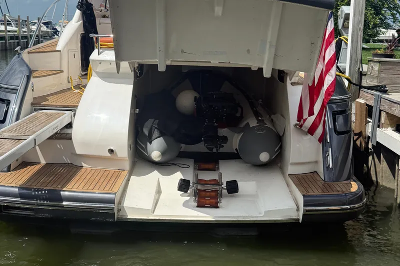 Slide: The Image of 2006 Princess V48 yacht with open storage compartment and American flag at dock. - 41