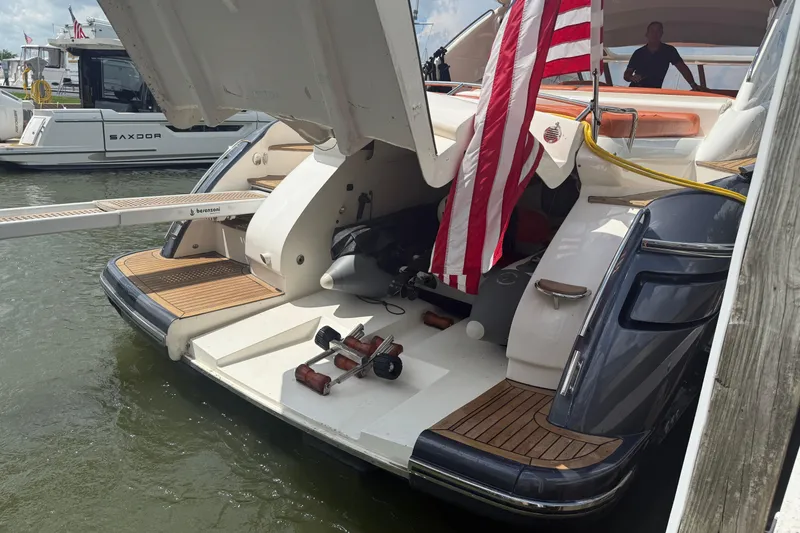 Slide: The Image of 2006 Princess V48 yacht with American flag, docked, featuring open stern and wooden deck. - 42