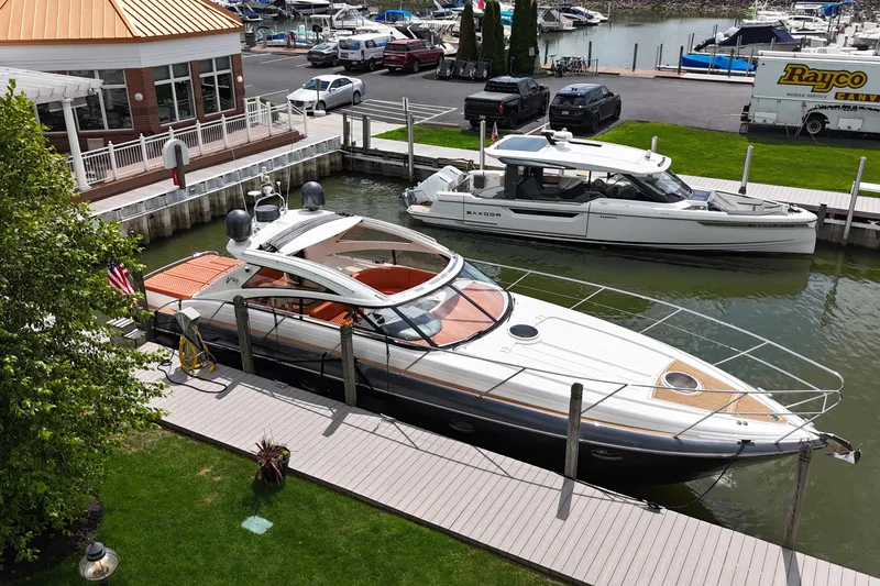 Slide: The Image of 2006 Princess V48 yacht docked at marina, surrounded by boats and greenery. - 43