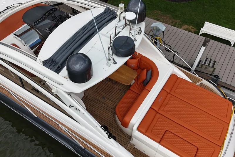 Slide: The Image of 2006 Princess V48 yacht with orange seating, docked at a marina. - 47