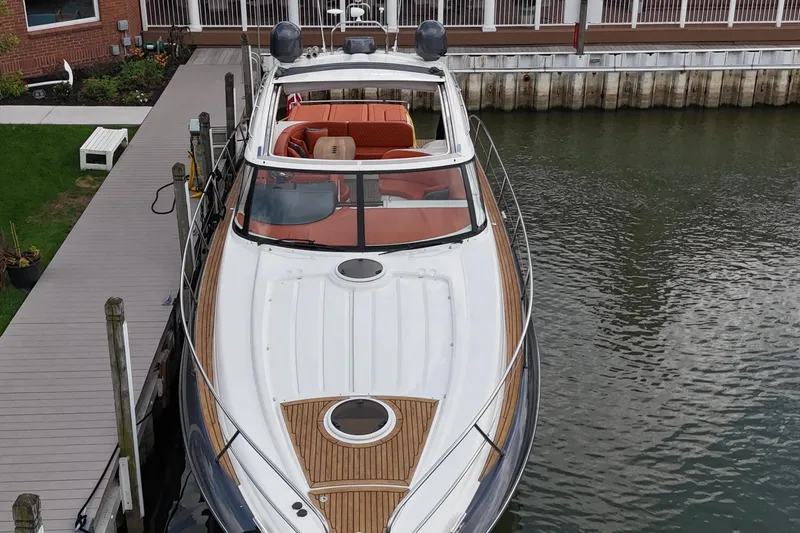 Slide: The Image of 2006 Princess V48 yacht docked at marina, featuring sleek design and spacious deck. - 49