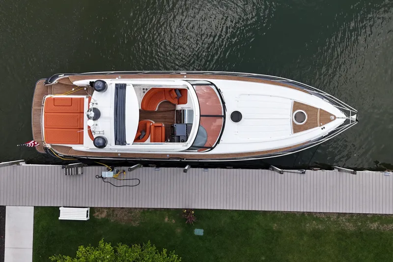 Slide: The Image of Overhead view of 2006 Princess V48 yacht docked, featuring sleek design and orange seating. - 50