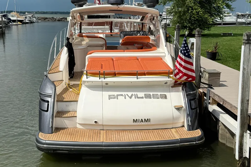 Slide: The Image of Luxury 2006 Princess V48 yacht docked, featuring orange seating and American flag. - 51