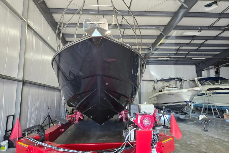 Slide: The Image of 2006 Princess V48 yacht in a storage facility, front view with other boats. - 53