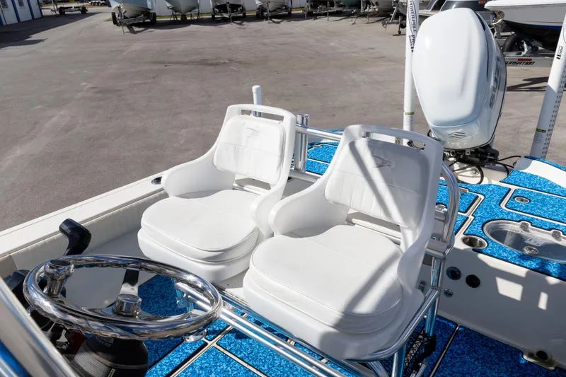 Slide: The Image of 2018 Sea Chaser 23 LX Bay Runner boat interior with white seats and steering wheel. - 4