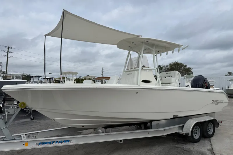 The Image of 2026 Pathfinder 2400 TRS boat on trailer, featuring a sleek design and canopy. - 0
