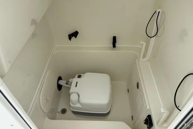 Slide: The Image of 2026 Pathfinder 2400 TRS boat interior with compact marine toilet setup. - 1