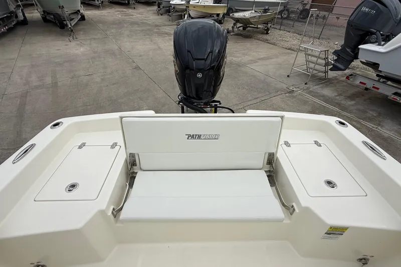 Slide: The Image of 2026 Pathfinder 2400 TRS boat with rear seating and outboard motor in a marina setting. - 12