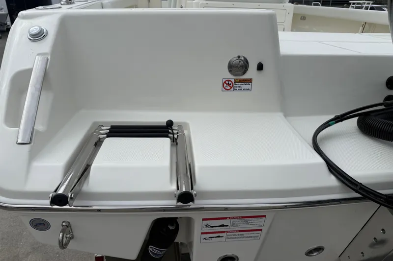 Slide: The Image of 2026 Pathfinder 2400 TRS boat stern with ladder and warning labels. - 19