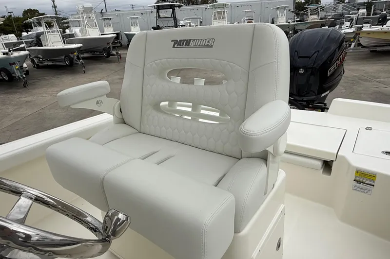 Slide: The Image of 2026 Pathfinder 2400 TRS boat seat with armrests, in a marina setting. - 8