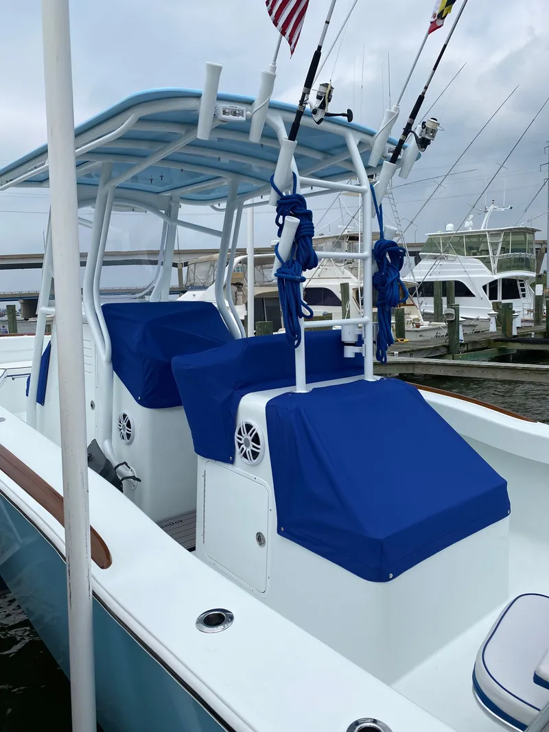 Slide: The Image of 2023 Valentino 28CC boat with blue covers docked at marina. - 14