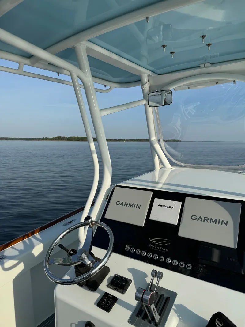 Slide: The Image of Valentino 28CC boat 2023 with Garmin displays on calm water. - 24