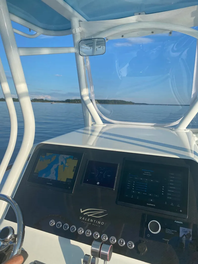 Slide: The Image of Valentino 28CC 2023 boat console with navigation systems on calm waters. - 25