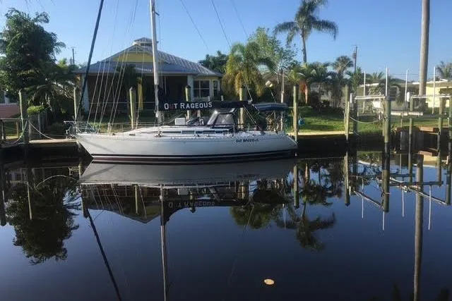 The Image of 1987 Beneteau First 375 sailboat on stands, undergoing maintenance and painting. - 0