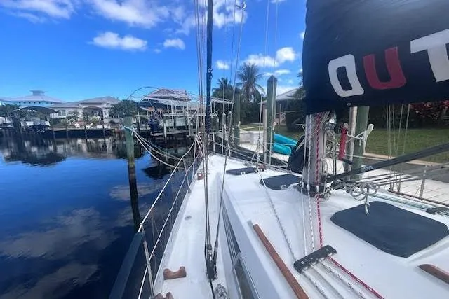 Slide: The Image of 1987 Beneteau First 375 sailboat docked by a tropical waterfront home. - 1