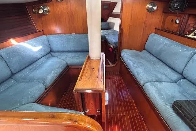 Slide: The Image of Interior of 1987 Beneteau First 375 sailboat with blue seating and wooden finishes. - 10