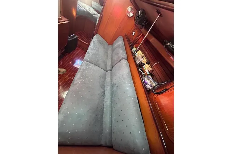 Slide: The Image of Interior of 1987 Beneteau First 375 sailboat with cushioned seating and wooden paneling. - 16