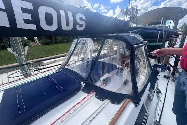 Slide: The Image of 1987 Beneteau First 375 sailboat docked in a serene marina under a clear blue sky. - 2