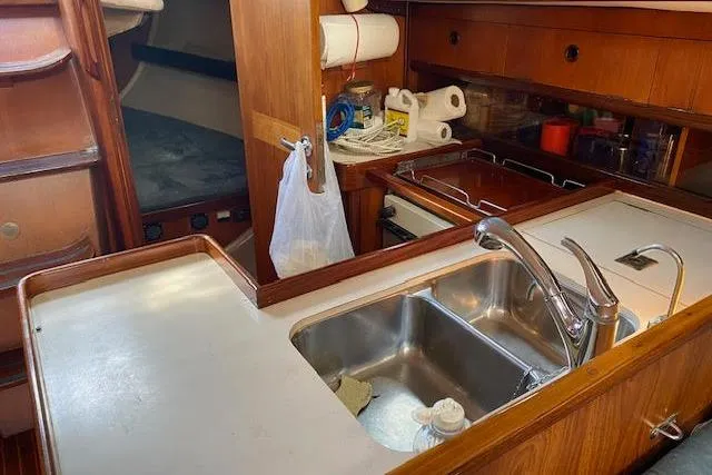 Slide: The Image of 1987 Beneteau First 375 yacht interior with wooden cabinetry and kitchen sink. - 24