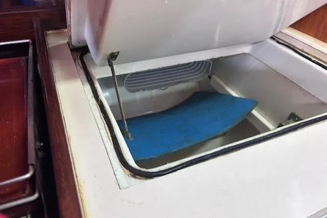 Slide: The Image of Open storage compartment on a 1987 Beneteau First 375 sailboat, featuring a blue mat inside. - 29