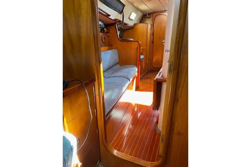 Slide: The Image of Interior of 1987 Beneteau First 375 sailboat with wooden finish and seating area. - 30
