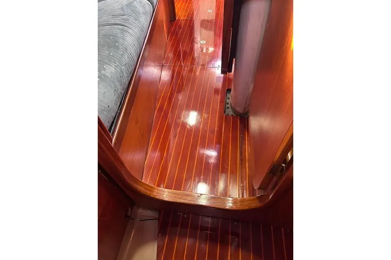 Slide: The Image of Polished wooden interior of 1987 Beneteau First 375 sailboat, featuring sleek flooring and cozy seating. - 33