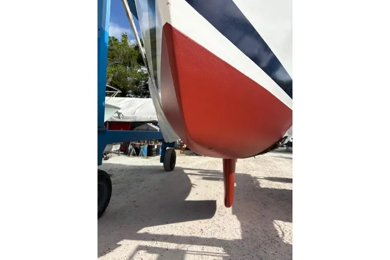 Slide: The Image of 1987 Beneteau First 375 sailboat keel, red and white, on dry dock. - 40