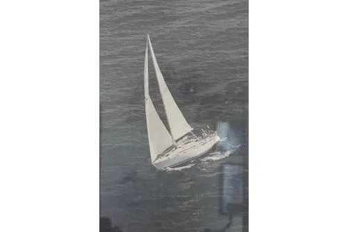 Slide: The Image of 1987 Beneteau First 375 sailboat navigating open waters with full sails. - 41