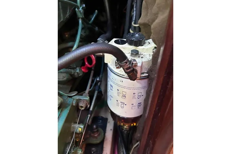 Slide: The Image of Engine compartment of a 1987 Beneteau First 375 sailboat, showing mechanical components and connections. - 45
