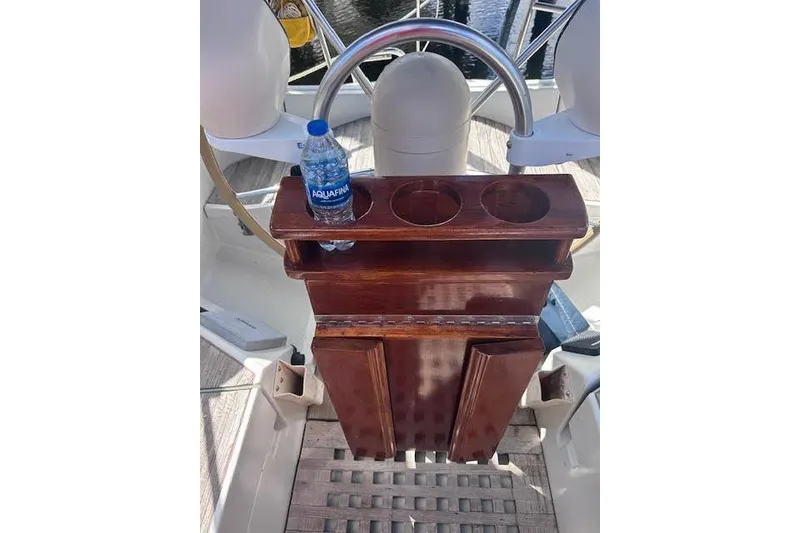 Slide: The Image of Wooden helm station on 1987 Beneteau First 375 sailboat with cup holders and water bottle. - 7