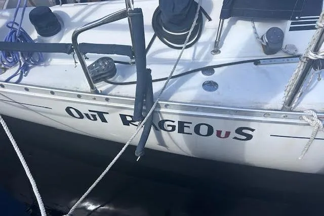 Slide: The Image of 1987 Beneteau First 375 sailboat named "Outrageous" docked with visible ropes and deck equipment. - 9