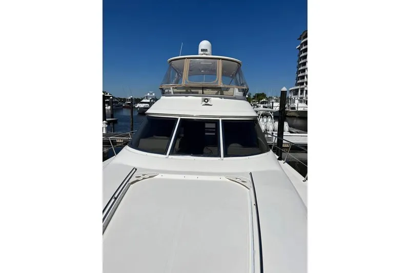 Slide: The Image of 2001 Sea Ray 480 Sedan Bridge yacht docked at marina under clear blue sky. - 18