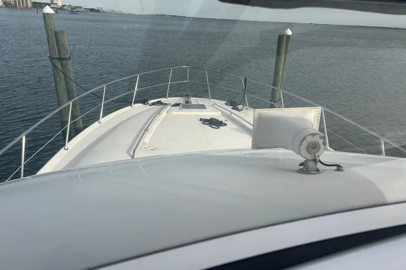 Slide: The Image of 2001 Sea Ray 480 Sedan Bridge yacht bow view, docked in calm waters. - 19