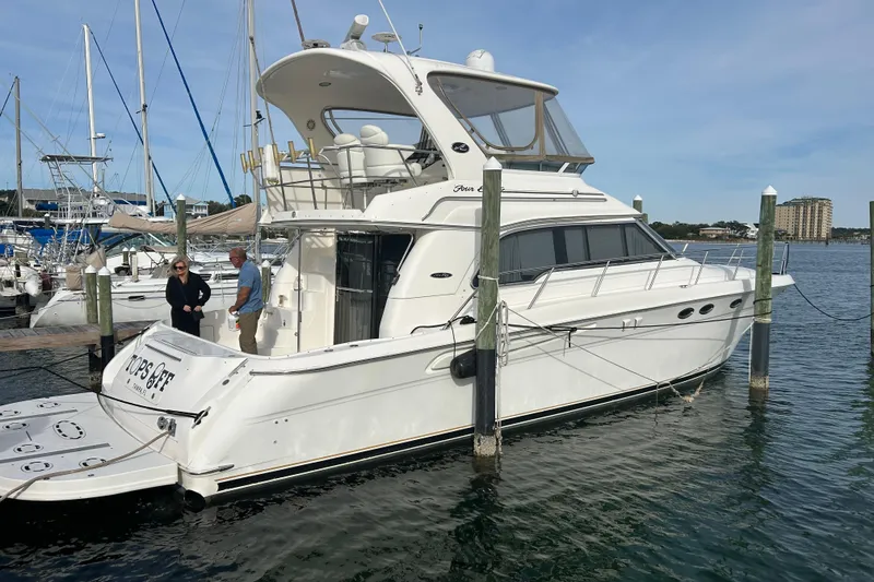 Slide: The Image of 2001 Sea Ray 480 Sedan Bridge yacht docked at marina with two people onboard. - 2