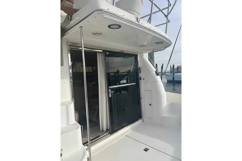Slide: The Image of 2001 Sea Ray 480 Sedan Bridge yacht with sliding glass door and outdoor seating area. - 21