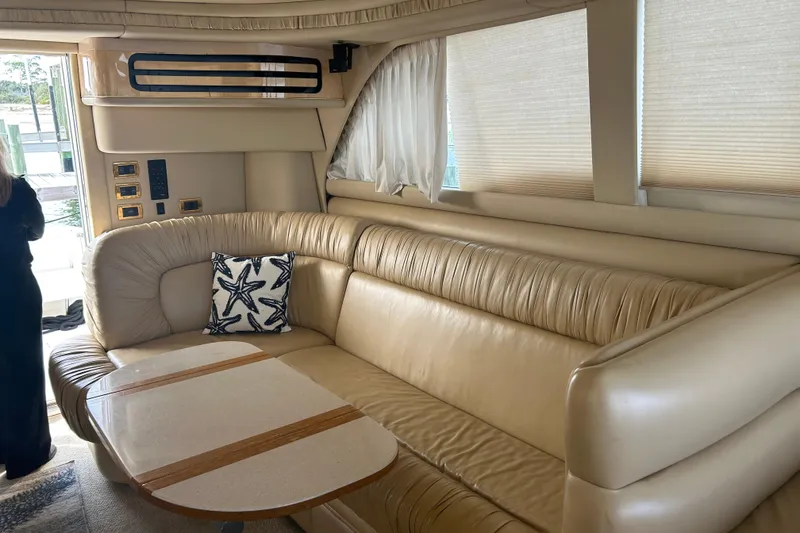Slide: The Image of Luxurious interior of 2001 Sea Ray 480 Sedan Bridge with beige leather seating and starfish pillow. - 24