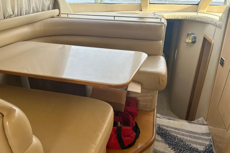 Slide: The Image of Interior of 2001 Sea Ray 480 Sedan Bridge with beige seating and table. - 26