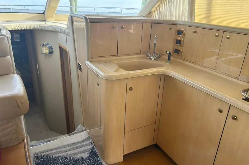 Slide: The Image of 2001 Sea Ray 480 Sedan Bridge yacht interior with wooden cabinetry and sink. - 27